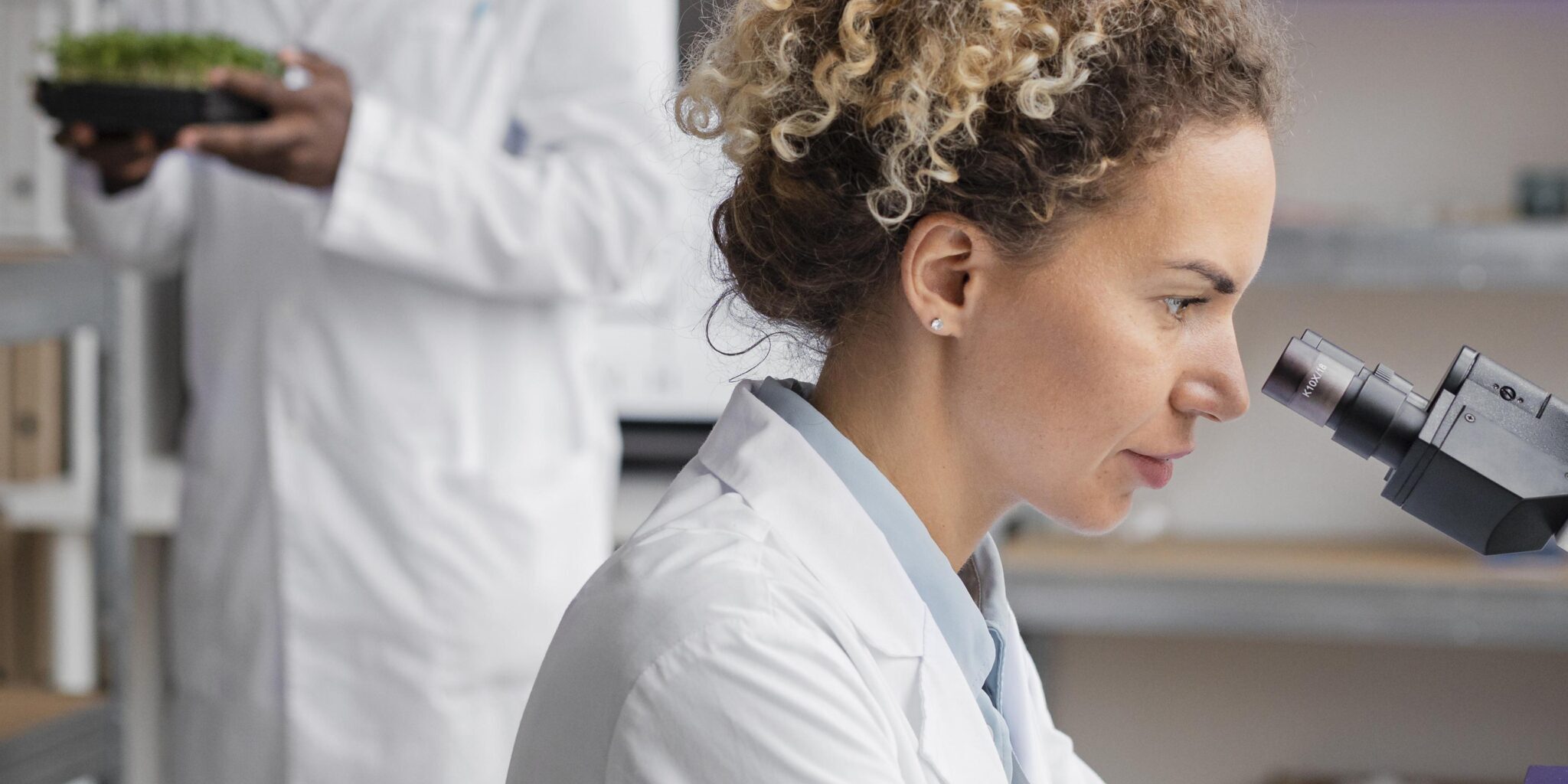 side-view-female-researcher-laboratory-with-microscope-male-colleague